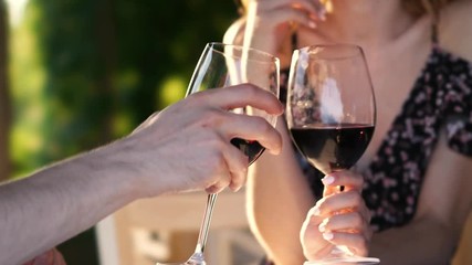 Poster - Cropped video closeup of young loving couple sitting outdoors drinking wine