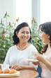 © DragonImages - Attractive aged Asian women sitting at table, drinking tea with croissants and enjoying warm friendly conversation