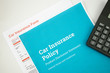 © winistudios - Top view of Car insurance concept with car insurense policy, form and calculator on a white background