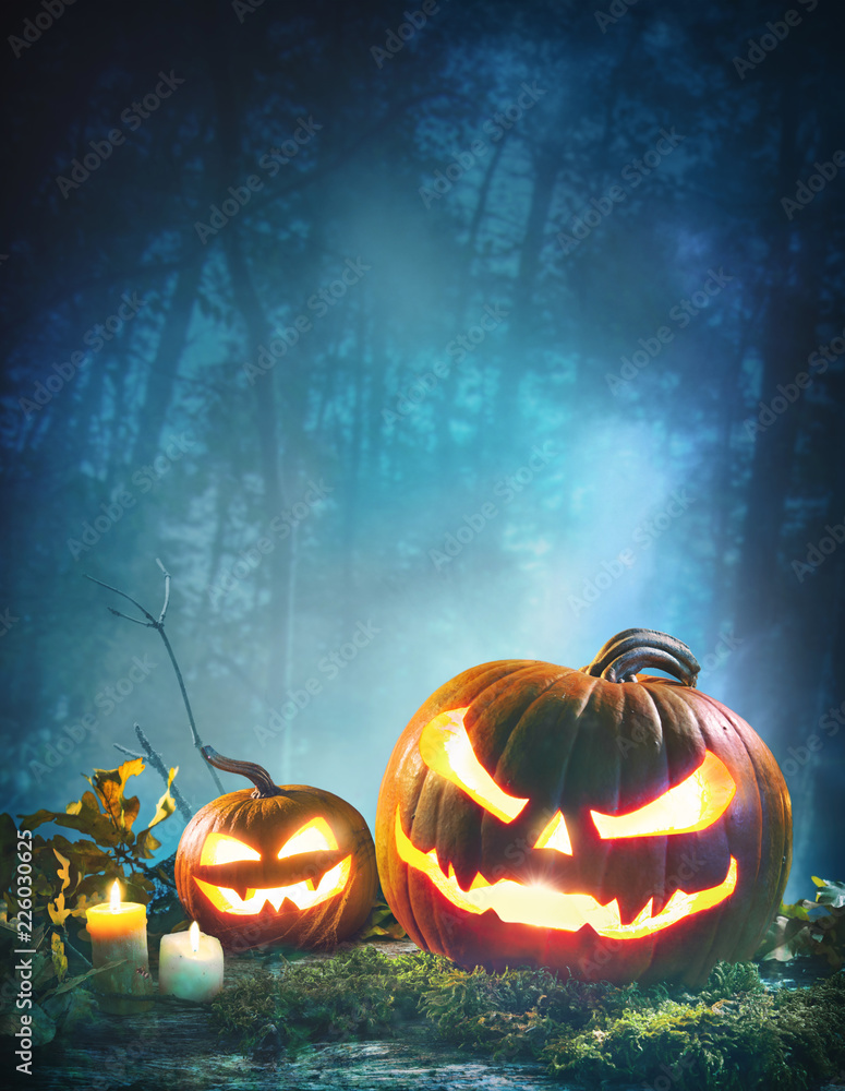 Jack o’ lanterns glowing at moonlight in front of spooky forest Stock ...
