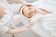 © alfa27 - Cosmetology RF lifting equipment. Anti-age and anti-wrinkle apatherapy. Top view of beautiful woman in white bathrobe getting facial treatment and looking at camera at Cosmetology Salon.