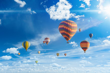 Colorful Hot Air Balloons Fly In Blue Sky With White Clouds And Bright Sunshinr