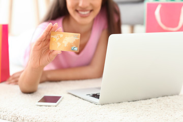 Poster - Young woman shopping online with credit card and laptop at home