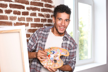 Wall Mural - Young African-American artist painting picture in workshop