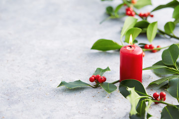 Wall Mural - christmas decorations, candle and holly leaves with red berries.