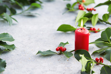 Wall Mural - christmas decorations, candle and holly leaves with red berries.