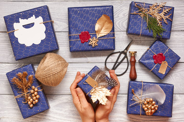 Sticker - Woman wrapping christmas presents over wooden background