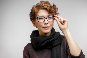 Autumn Fashion and Beauty Portrait of ginger charming fashionably dressed caucasian woman in optical eyeglasses, wearing black warm scarf.