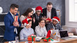 © Prostock-studio - Group of young business people in Santa hats in office
