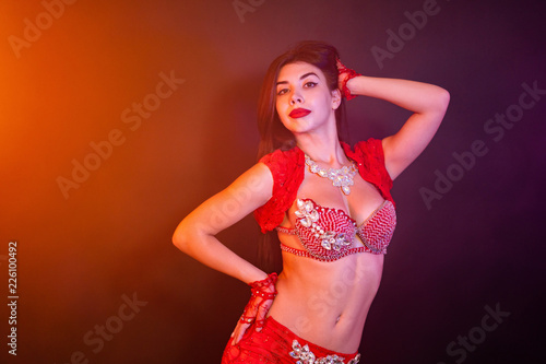 Tempting Sexy Traditional Oriental Belly Dancer Girl Dancing On Purple Neon Smoke Background Woman In Exotic Red Costume Sexually Moves Her Semi Nude Body Stock Photo Adobe Stock