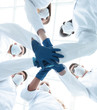 © ASDF - Doctors and nurses in a medical team stacking hands