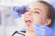 © lenets_tan - Young Female patient with open mouth examining dental inspection at dentist office.