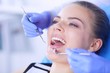 © lenets_tan - Young Female patient with open mouth examining dental inspection at dentist office.