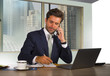 © TheVisualsYouNeed - happy and attractive successful businessman working at modern office in central business district smiling satisfied and confident talking on mobile phone taking notes