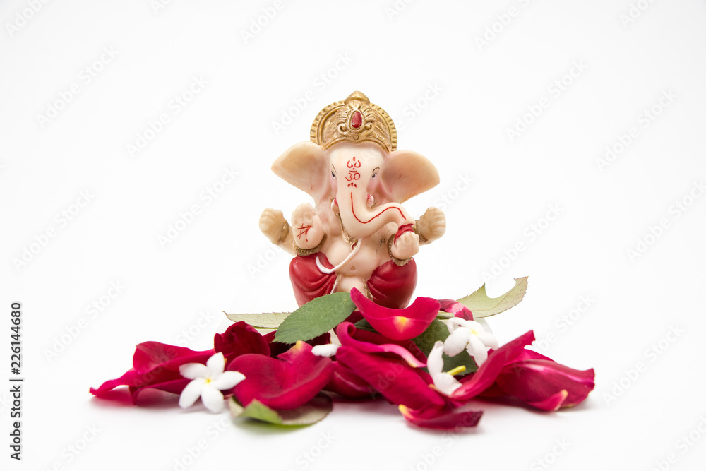 Lord Ganesha Idol with rose petals on white background, ganesh chaurthi, ganesh pooja - obrazy, fototapety, plakaty 