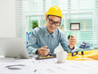 © Phushutter - Young Asian man architect working at working desk about his housing project.