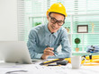 © Phushutter - Young Asian man architect working at working desk about his housing project.