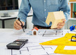 © Phushutter - Young Asian man architect working at working desk about his housing project.