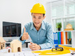 © Phushutter - Young Asian man architect working at working desk about his housing project.