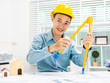 © Phushutter - Young Asian man architect working at working desk about his housing project.