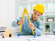 © Phushutter - Young Asian man architect working at working desk about his housing project.