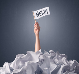 Wall Mural - Female hand emerging from crumpled paper pile holding a white flag with help written on it