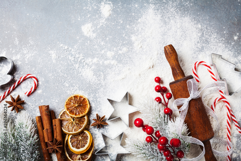 Bakery background for cooking christmas baking with rolling pin, scattered flour and spices decorated with fir tree top view. - obrazy, fototapety, plakaty 
