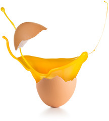 yolk splashing out of a broken egg isolated on white