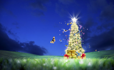 Wall Mural - Conceptual decorated shiny Christmas tree on green landscape and flying butterflies over clear night sky