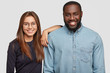 © WHstudio Leushin N - Horizontal shot of mixed race couple stand closely to each other, being in good mood, collaborate for common work, have good relationships, isolated over white background. Interracial partners