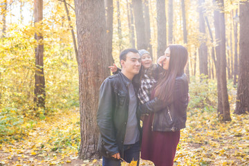 Wall Mural - Parenthood, fall and people concept - young family happy in autumn park