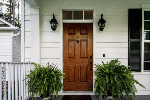 Cuadros en Lienzo Brown Wood Front Door of a White Siding Southern House