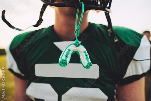 Fotografía Mouthguard hanging off the helmet of an American football player