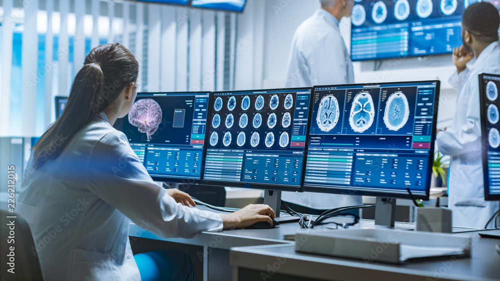 Team of Professional Scientists Work in the Brain Research Laboratory. Neurologists / Neuroscientists Surrounded by Monitors Showing CT, MRI Scans Having Discussions and Working on Personal Computers. - obrazy, fototapety, plakaty 