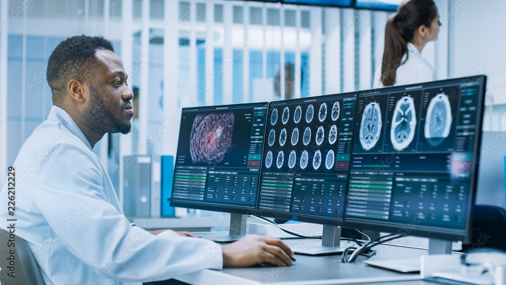 Medical Scientist Working with CT Brain Scan Images on a Personal Computer in Laboratory. Neurologists in Neurological Research Center Working on a Brain Tumor Cure. - obrazy, fototapety, plakaty 