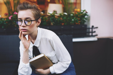 business woman in glasses with a notebook thinks