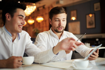 Wall Mural - Young businessman with tablet in cafe