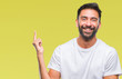 © Krakenimages.com - Adult hispanic man over isolated background with a big smile on face, pointing with hand and finger to the side looking at the camera.