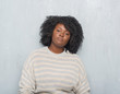 © Krakenimages.com - Young african american plus size woman over grey grunge wall wearing a sweater with serious expression on face. Simple and natural looking at the camera.