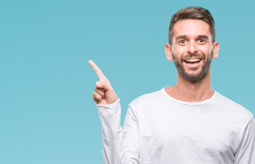 Young handsome man over isolated background with a big smile on face, pointing with hand and finger to the side looking at the camera.