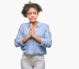 Sticker - Young afro american woman over isolated background begging and praying with hands together with hope expression on face very emotional and worried. Asking for forgiveness. Religion concept.