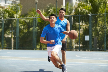 young asiian men playing basketball