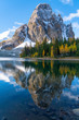 Sunburst Peak reflects perfectly into Sunburst Lake full of fall colors