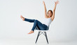 woman sitting on a chair with arms raised
