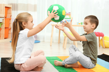 Canvas Print - Cute little children playing with ball at home