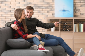 Poster - Young couple watching TV at home