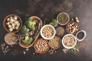 Wall Mural - Vegan protein source. Tofu, beans, chickpeas, nuts and seeds on a dark background, top view, copy space.