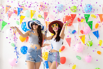 celebration new year or birthday party group of asian young woman and confetti happy,funny concept.drinking wine happy and fun in new year celebrate, color balloon  background.