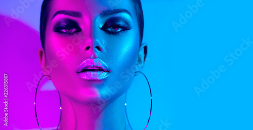 Cuadros en Lienzo Fashion model brunette woman in colorful bright neon lights posing in studio