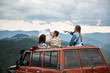 © Yakobchuk Olena - Active group of young travelers sitting in their off road car while studying their map of the mountains